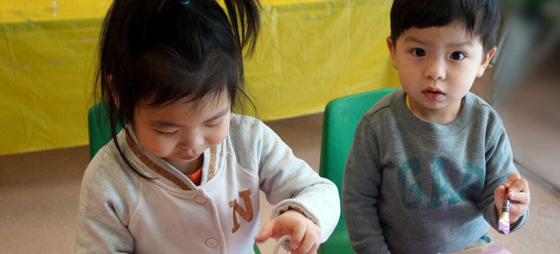 two young children painting