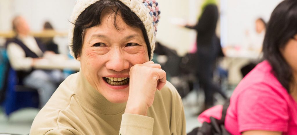 an older asian woman smiling at someone to her left