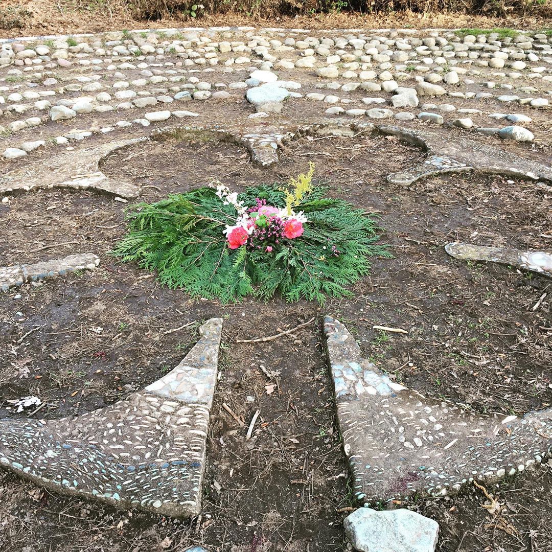 The Renfrew Ravine Labyrinth with an arrangement of cedar leaves and flowers at the centre.