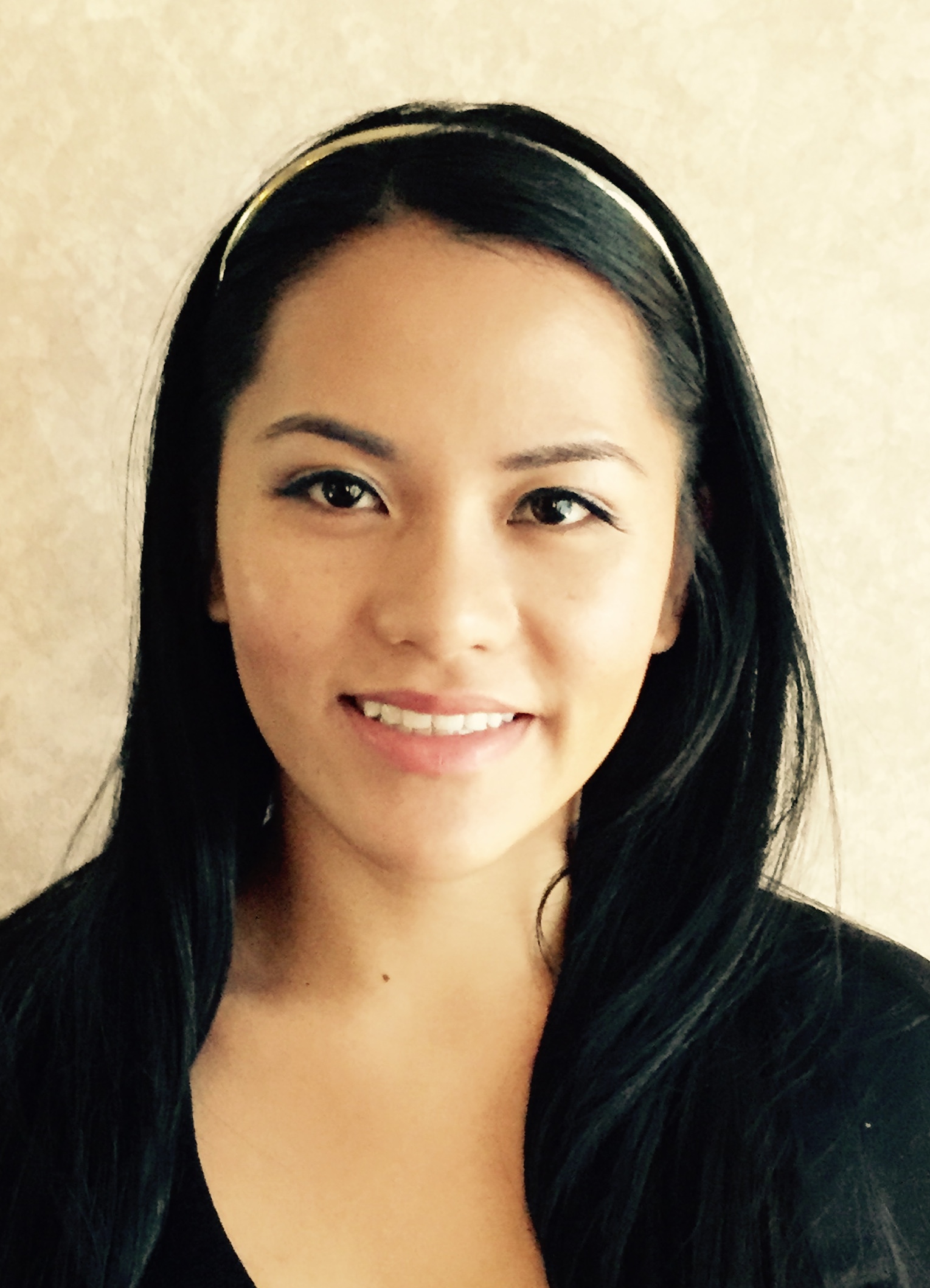 A close-up of a woman with long dark hair wearing a dark shirt